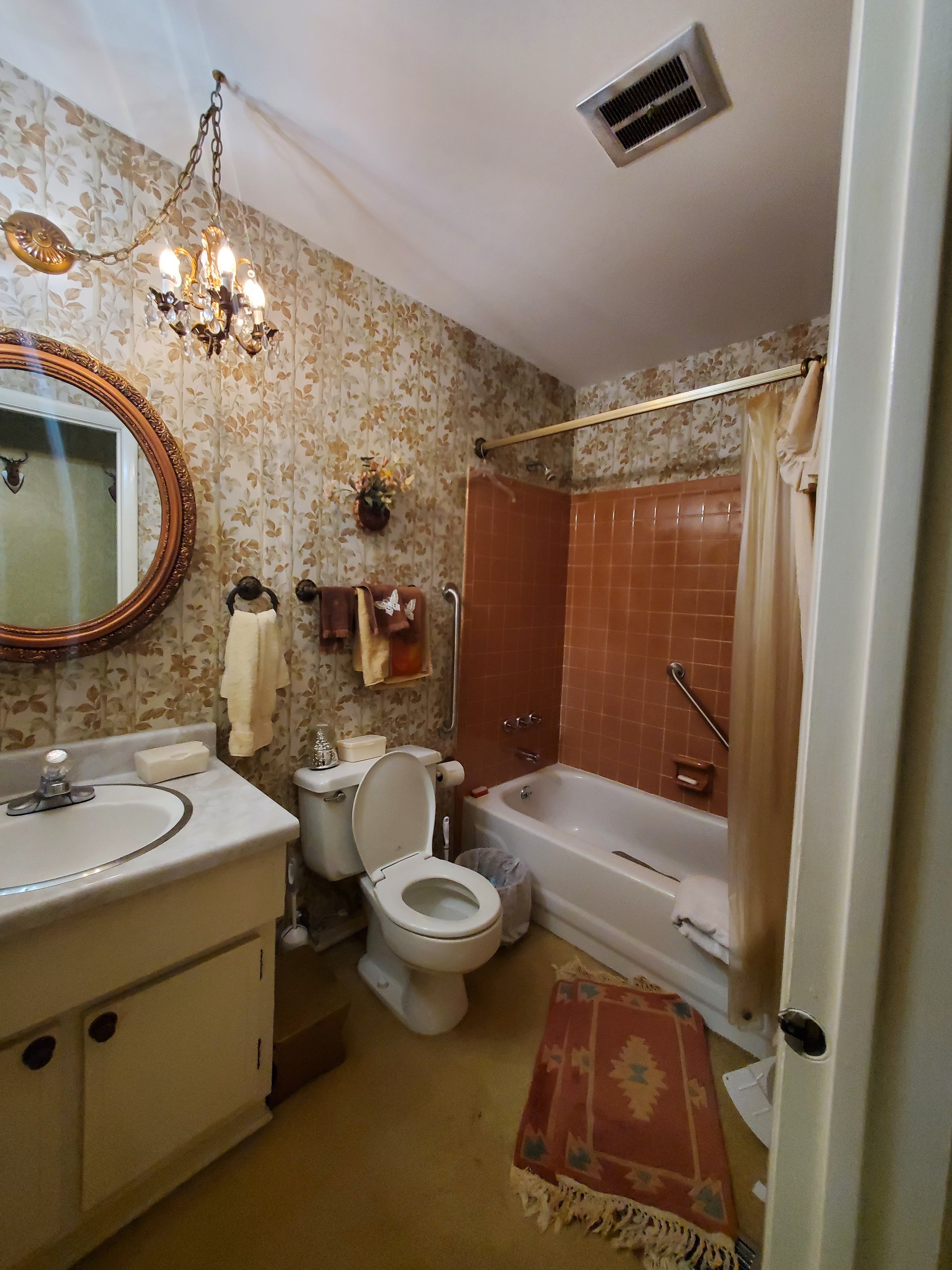 Bathroom with floral wallpaper and chandelier