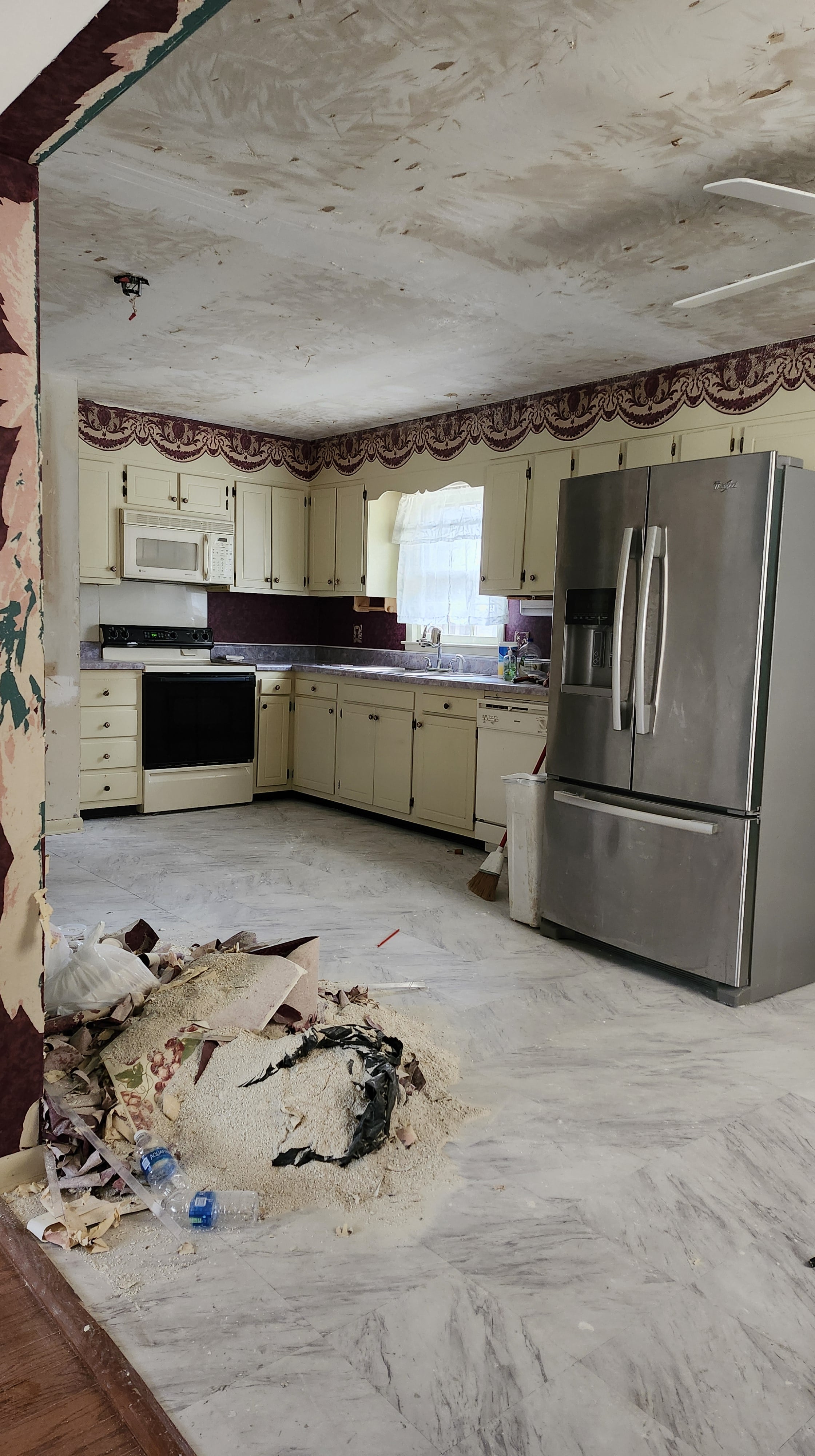 Kitchen with ceiling damage and debris on floor